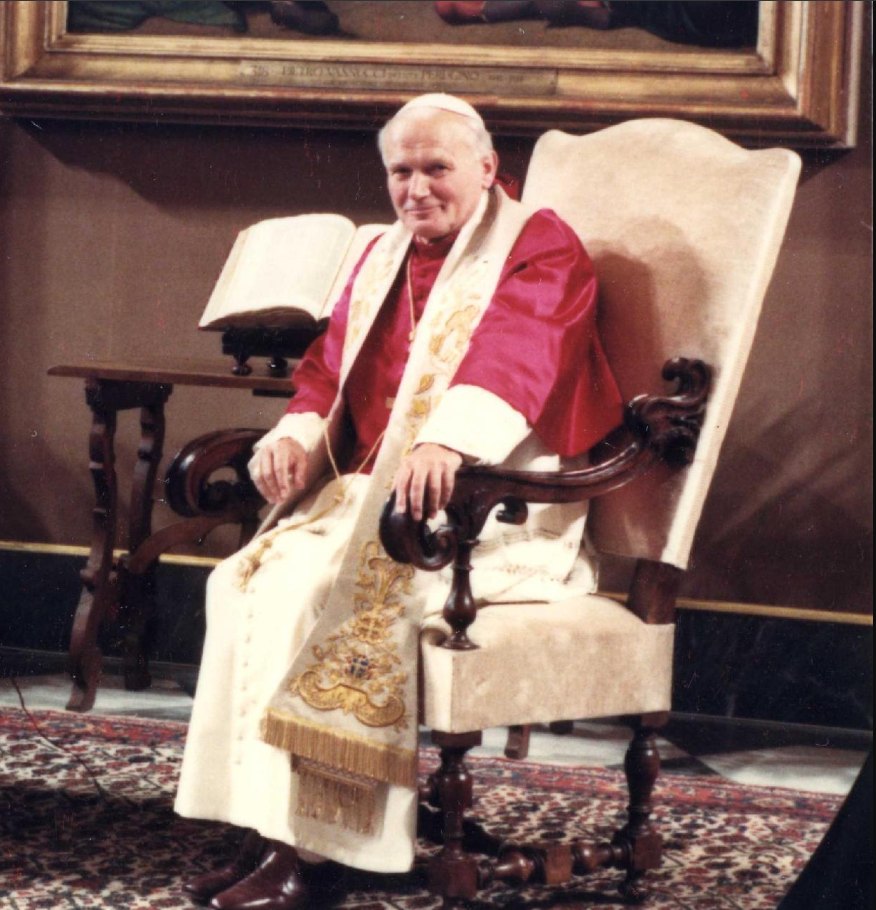 St. Pope John Paul II, seated and facing toward the story